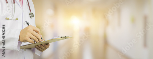 Male Doctor with files and stethoscope on hospital corridor holding clipboard and writing prescription,Doctor,Medical Exam Healthcare and medical concept,test results, registration,banner blackground