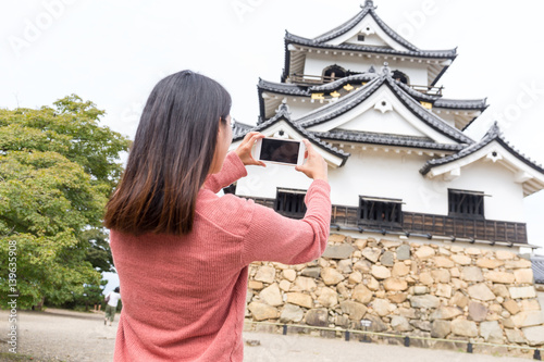 Woman taking photo on hikone castle in Japan