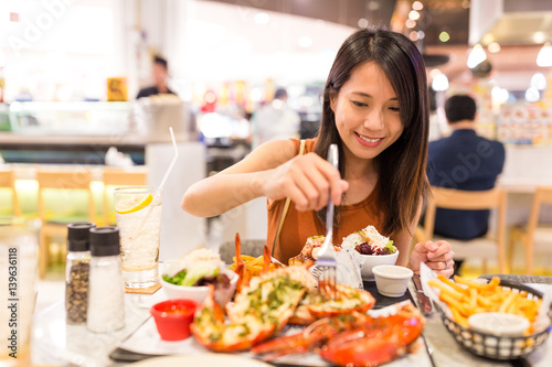 Woman enjoy her lobster in restaurant