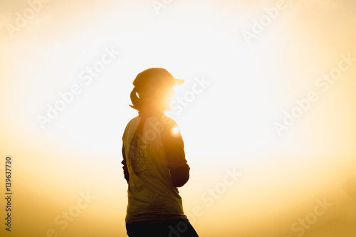 woman traveler at sunset or sunrise standing  reached mountain top summit goal during hiking travel trek