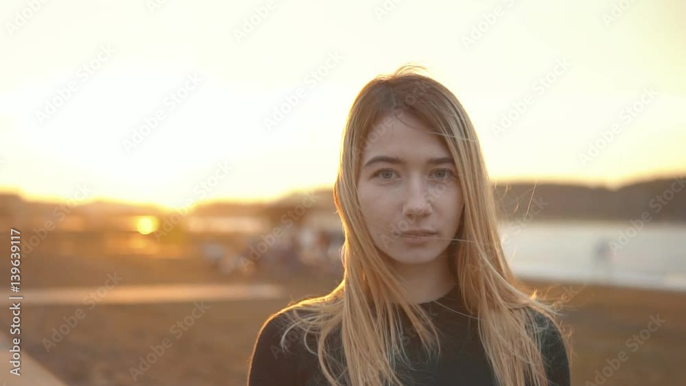 Smiling Blond Girl is Walking on Field at Sunset Smiling Blond Girl is Walking on Field at Sunset