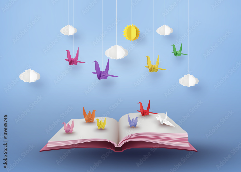 origami made colorful paper bird flying over open book - obrazy, fototapety, plakaty 