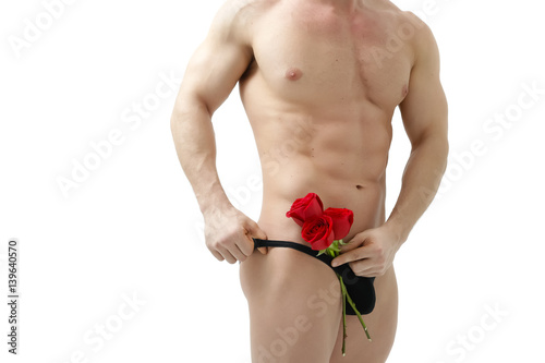 Foto Handsome man holding a red rose and a bouquet of red roses