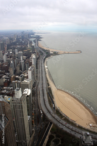Chicago skyline aerial view with road and deserted Michigan lake beach. An overhead view of the great city of Chicago downtown taken from the John Hancock Center skyscraper. Vertical composition.