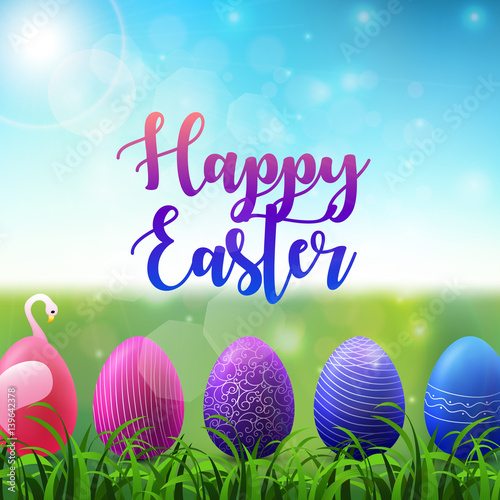 Easter background with colored easter eggs in the grass on sunny sky background