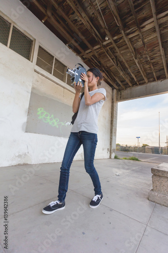 Girl Shooting 16mm Film Camera Next to Building