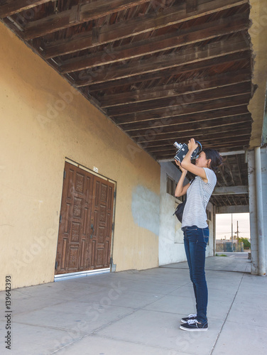 Girl Shooting 16mm Film Camera Next to Building
