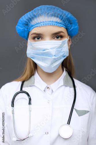 
Face of woman  doctor, nurse  in mask  with stethoscope. Close up 
 photo