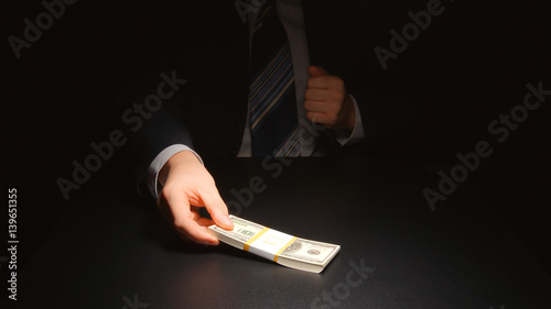 BRIBE: Businessman takes out a money from a pocket of a suit (US dollars)