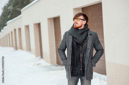 Stylish man in a coat on background of the house