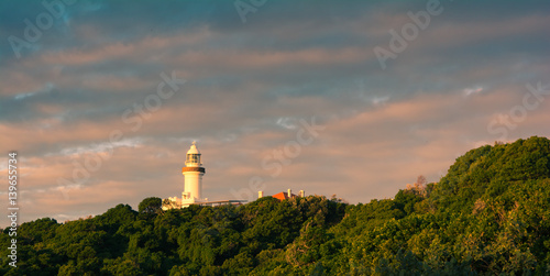 Canvas Print Byron Bay lighthouse view from the distance in a bright sunset light with cloudy
