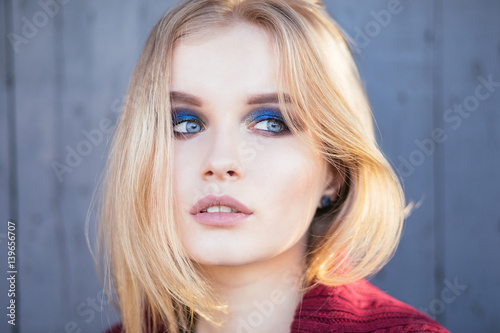 Portrait of a beauty young woman on the street.   Professional blue smoky eyes makeup for blonde with blue eyes 