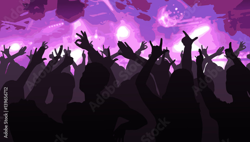 Silhouettes of dancing people in front of bright stage lights