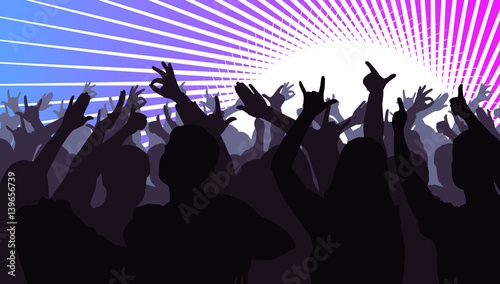 Silhouettes of dancing people in front of bright stage lights