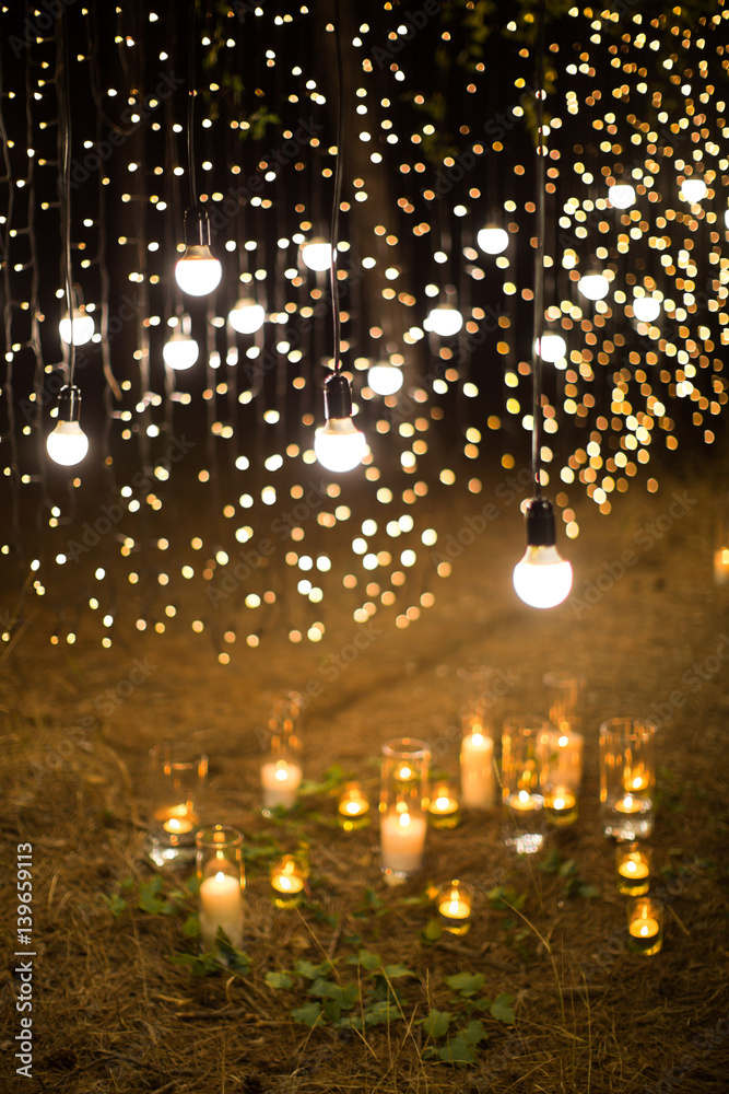 Wedding ceremony evening with candles and lamps in the coniferous pine forest