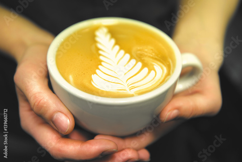 Cup of coffee. Latte art made by barista focus in milk and coffee. Vintage color