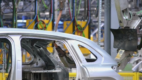 Robots weld a car body on the conveyor line
