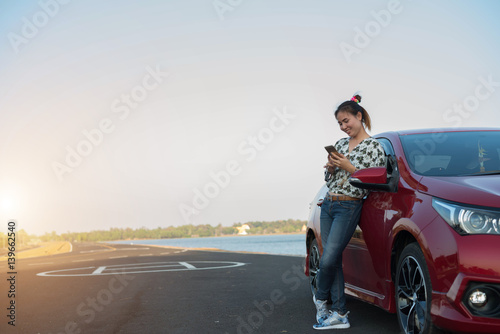 young woman playing mobile on the road