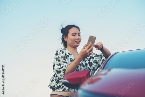 young woman playing mobile on the road
