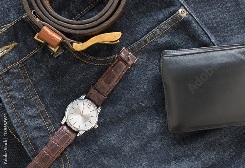 Wristwatch and wallet on denim jeans pocket
