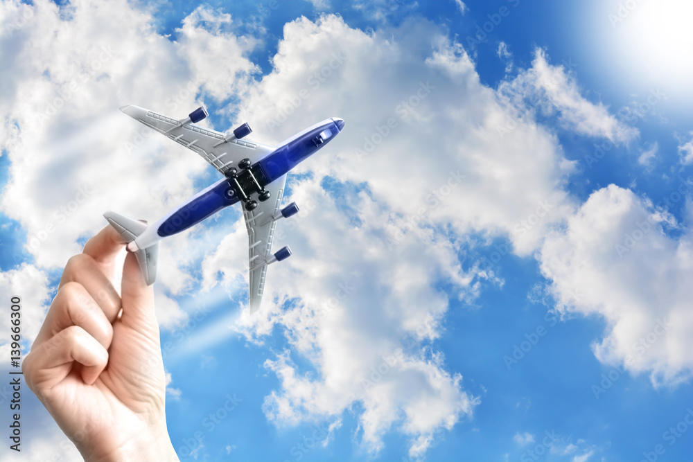 Airplane model in woman hand flying under the blue sky Airplane model in woman hand flying under the blue sky