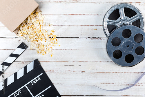 Top view of film reels, popcorn and movie clapper on wooden table, Movie time concept
