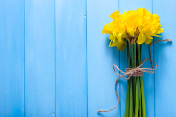 Foto auf Acrylglas Narzisse Frühlingsostern-Hintergrund mit Narzissenblumenstrauß auf Holztisch  © alicja neumiler