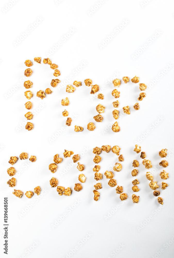 top view of popcorn lettering made of popcorn kernels on white