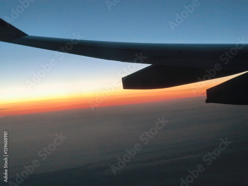 夕焼け空と雲と飛行機の翼