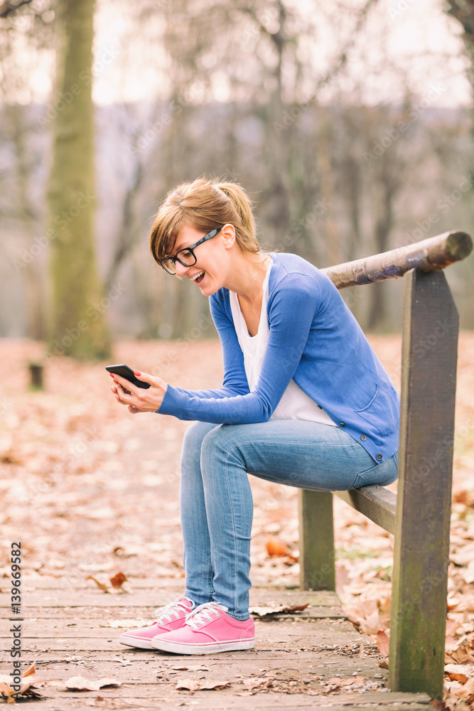 Woman using cellphone in nature.