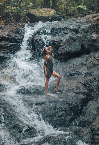 Sensual woman bathing on the waterfalls