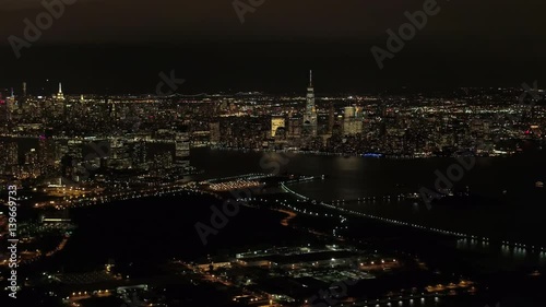 Wallpaper Mural AERIAL HELI SHOT: Flying above New Jersey port in industrial zone at night, overlooking iconic NYC Downtown skyline with brightly lit skyscrapers WITH Brooklyn and Queens cityscape in the background Torontodigital.ca