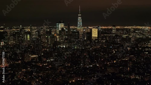 AERIAL HELI SHOT Flying above Midtown Manhattan residential area and Little Germany neighborhood looking toward downtown financial district & New Jersey in the background. City lights shining at night photo