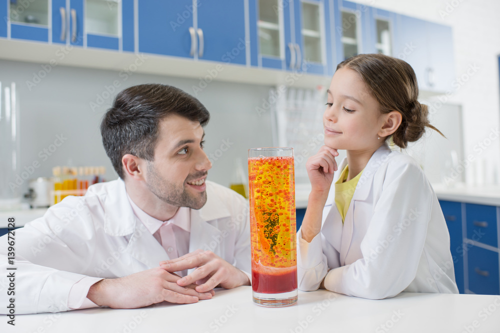 portrait of man teacher and girl student scientists making experiment in lab portrait of man teacher and girl student scientists making experiment in lab