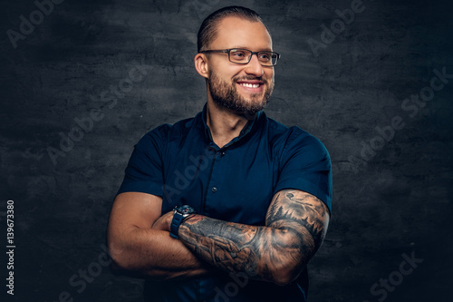 A man  in sunglasses with tattoo on his arm. © Fxquadro