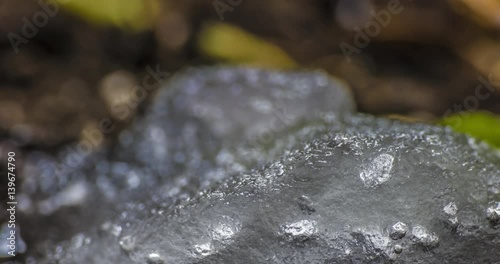 Melting Snow / Melting Ice / Spring Water / Spring Time. Macro time-lapse shot of shiny melting snow particles turning into liquid water. HDR color corrected.