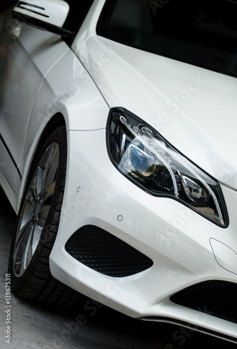 Close-up view of white sports car headlight. © M-Production