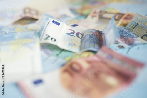 Close-up view of some Euro banknotes on a blurred geographical map showing some countries of the World.