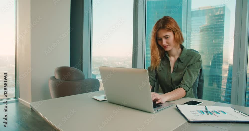 business woman in modern office skyscraper in the works at the table, a sunny day, the sun glare, steadicam shot business woman in modern office skyscraper in the works at the table, a sunny day, the sun glare, steadicam shot