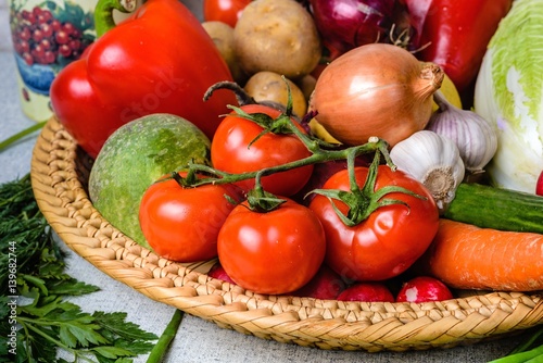 A variety of vegetables in wicker basket in the foreground a bra