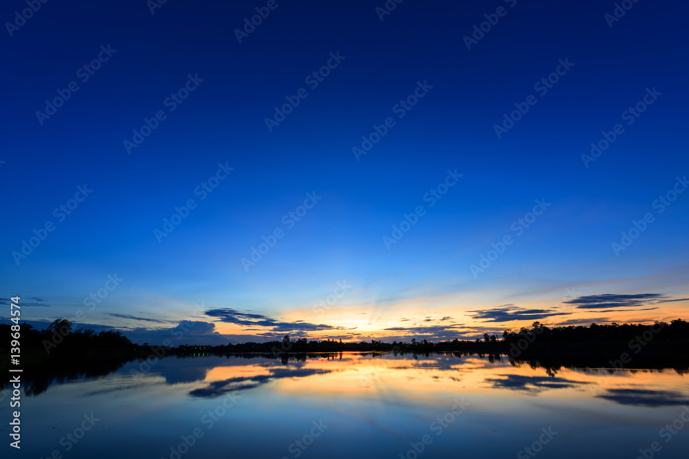 Breathtaking sunset over lake with blue sky