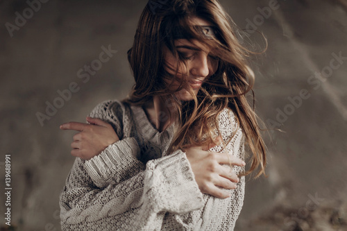 Beautiful hipster woman in boho indie clothes, posing in winter outdoor, face closeup, leather headband on brunnete hair photo