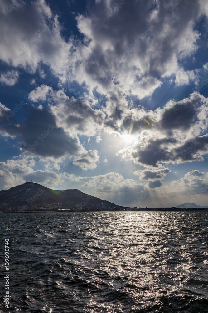 西日を映す函館港の海面と函館山