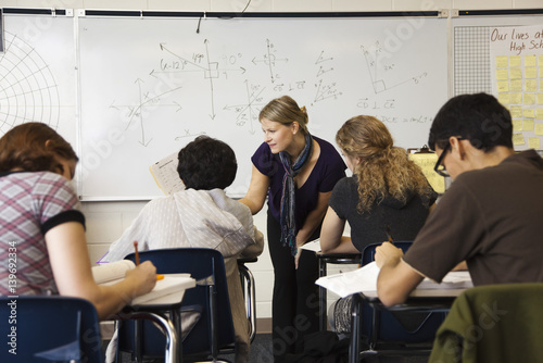 Teacher helping student in mathematics class