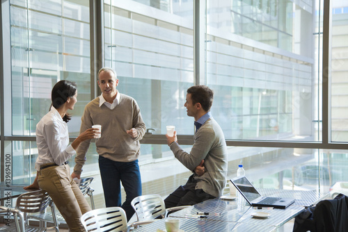 Colleagues taking coffee break in office cafeteria