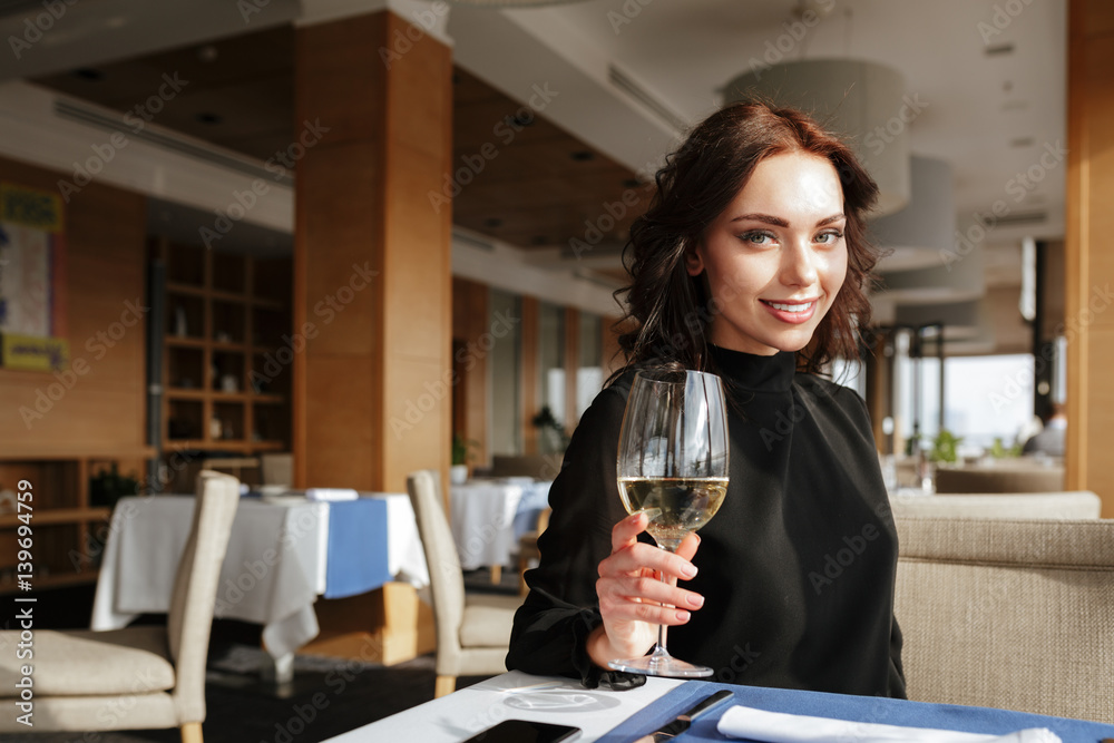 Smiling Woman in restaurant with wineglass Smiling Woman in restaurant with wineglass