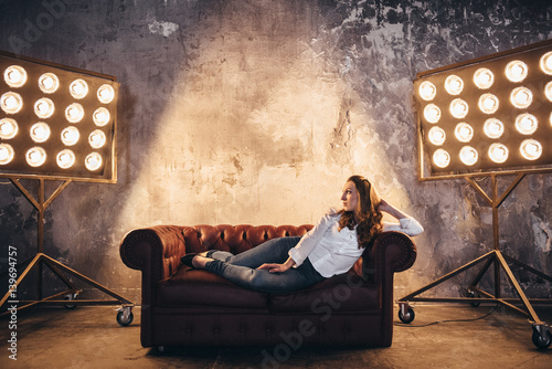 Fototapeta Girl actress on the couch in the light of soffits