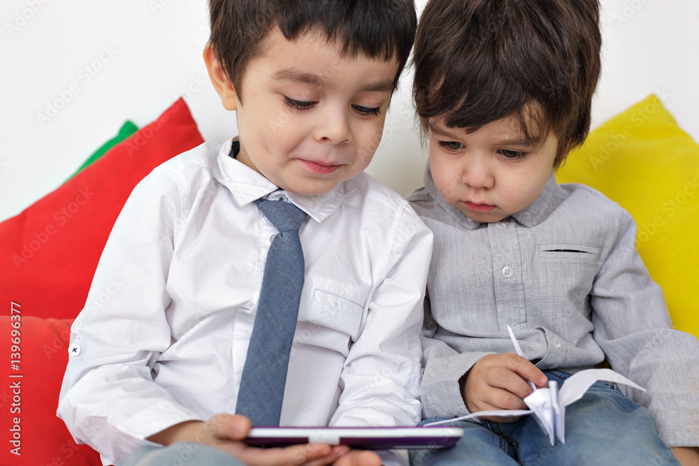 Two boys carefully watching video on smartphone. Learn modern techniques in childhood. Two boys carefully watching video on smartphone. Learn modern techniques in childhood.