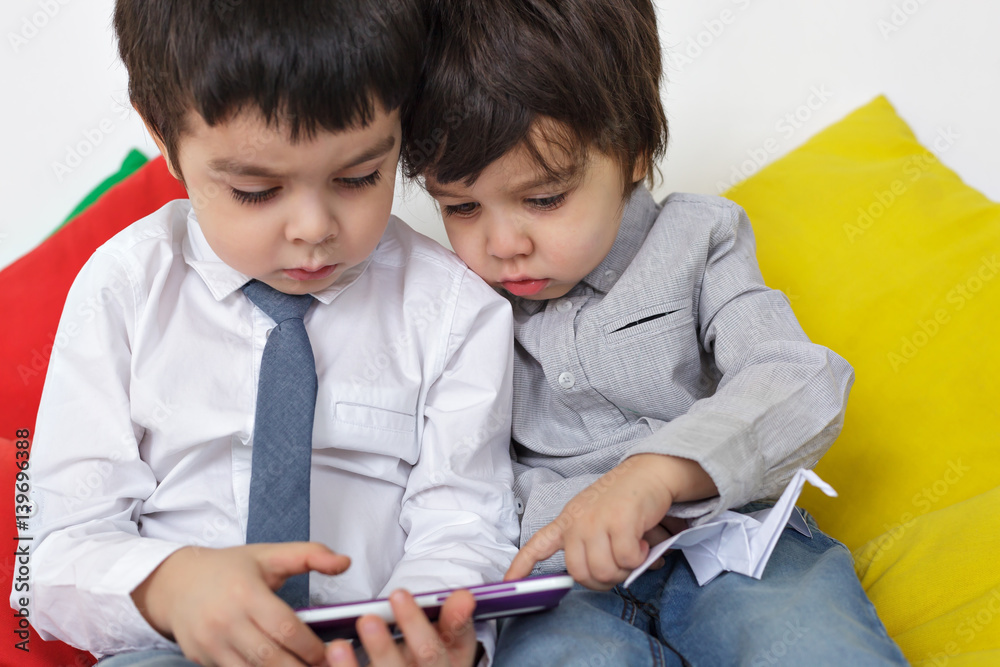 Two boys carefully watching video on smartphone. Learn modern techniques in childhood. Two boys carefully watching video on smartphone. Learn modern techniques in childhood.