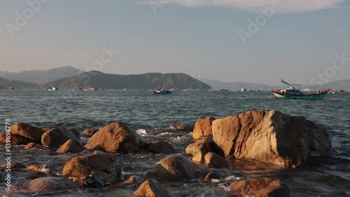 A coastline scene looking out over the south China sea in Vung Lam Bay Vietnam. With a small fleet of fishing boats going about there business.